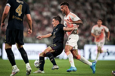 Serie A 2024-25 Juventus vs Roma: Juventus' Andrea Cambiaso fights for the ball with Roma's Lorenzo Pellegrini